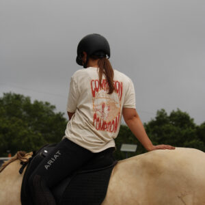 cavalière de mountain trail sur son cheval crème porte un t-shirt d'équitation en coton biologique sur le bien-être équin